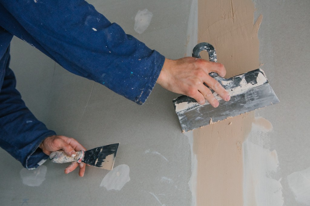Drywall technician applying compound for a smooth wall finish
